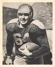 Black and white portrait of Fritsch in uniform running with a football