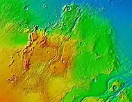 Tempe Terra as seen in MOLA colorized image. Red areas show highest elevations; blue, lowest. Acidalia Planitia is the blue area at extreme right. The immense outflow channels of Kasei Valles is in the lower right.