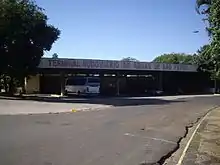 Asphalted street with a bus terminal in the background with a parked bus