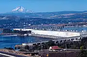 Looking west, fish ladder in the foreground, power generation center. Mount Hood rises in the background.