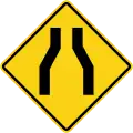 Road narrows on both sides