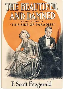 Cover of Fitzgerald's 1922 novel, The Beautiful and Damned, by illustrator W. E. Hill. The cover appears to be a pencil sketch and depicts a young couple who resemble F. Scott Fitzgerald and his wife Zelda. The couple is reclining on a divan in the foreground with a large golden circle in the background. The young man is in a dark suit with a bow-tie and white shirt. His arms are folded as if unhappy. The young woman is bra-less and has her legs crossed. Her hair is bobbed and she is wearing high heels.