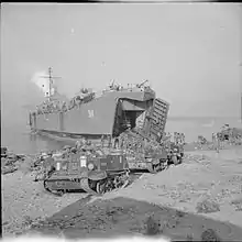 Photograph of Universal Carriers landing on a beachhead