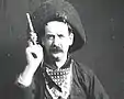 An outlaw raising his gun toward the camera