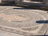 A close-up view of the floor mosaic containing a circle-within-a-square design