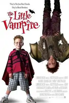 A boy with glasses wearing a cape. Another boy hanging upside down.