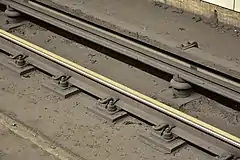 Third rail (top) at Bloor-Yonge station (Line 1) on the Toronto subway. Energized at 600 volts DC, the third rail provides electrical power to the power-train, and ancillaries of the subway cars.