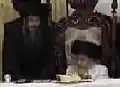 Rabbi Elimelech Segal-Loewy (left), son-in-law of the Zidichover Rebbe, standing next to his father, the Tosher Rebbe (seated)