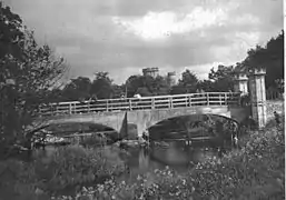 A view of the whole of the repaired bridge. Note the army personnel, children fishing, etc.