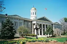 A courthouse, seen beyond landscaped grounds