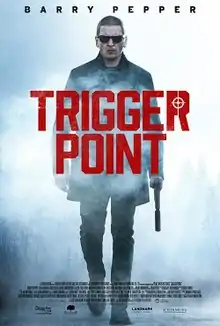 A man wearing shades holds a silencer while walking in a mist, with the words "Trigger Point" placed in front of him in red font.