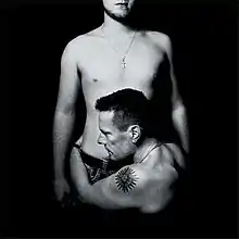 A black and white photo of a man holding another man's torso