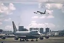 Boeing 747 on the runway and 707 in the air