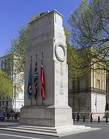 A grey/white stone monument in the middle of a street