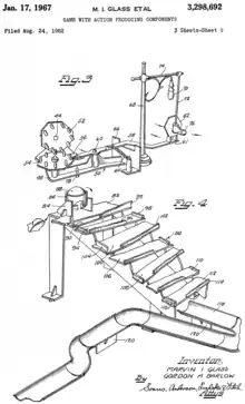 The player initially turns a crank, rotating gears that pull back a lever with a plastic stop sign at the end. Once the crank is released, the lever snaps back so the stop sign hits a shoe hanging from a lamppost. The shoe then knocks down a bucket positioned at the top of a staircase that contains a metal ball. The ball then falls down the staircase and then down a rain gutter.