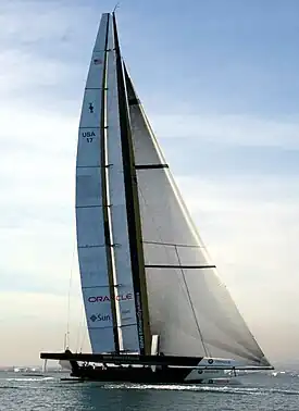 Color photograph of a racing catamaran underway with the starboard hull out of the water