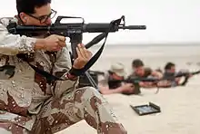 A USAF security policeman aims his GAU-5/A during a live-fire demonstration, part of Operation Desert Shield.