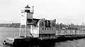 The configuration of the lighthouse from 1912 - 1931, with an open frame tower and the fog signal building behind it. This photo was taken between 1919 and 1930 when the fog signal was a compressed air diaphone.