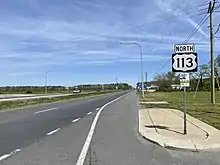 A four-lane road with a grassy median in a rural area