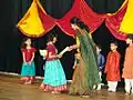 Schoolgirls dressed in langa and ravike for Ugadi. The woman is wearing a sari. The boys are wearing the kurta.