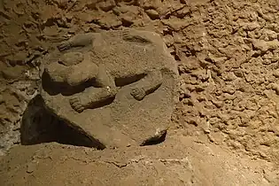 Carved stone with animal (possibly a reptile, felid, or wolverine) in high relief