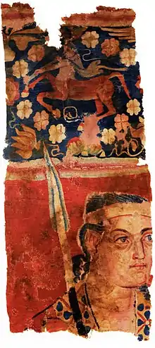 The Sampul tapestry, a woollen wall hanging from Lop County, Hotan Prefecture, Xinjiang, China, showing a possibly Greek soldier from the Greco-Bactrian kingdom (250–125 BC), with blue eyes, wielding a spear, and wearing what appears to be a diadem headband; depicted above him is a centaur, from Greek mythology, a common motif in Hellenistic art; Xinjiang Region Museum.