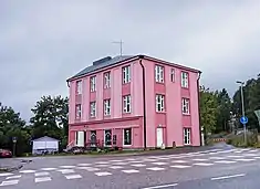 A pink building at Vesijärventie in Vääksy, the oldest apartment building of village. Previously served as a guest house and as residence. Today as a ’French-style village shop’.