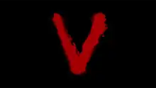 The letter 'V' daubed in red paint on a black background