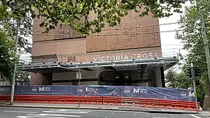 Picture of Victoria Cross station under construction from street level.