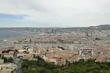 Elevated view of the Old Port of Marseille with red tile-roofed surrounding a quay of yachts