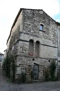 House in Villemagne-l'Argentiere, France, with carved details on doors and windows.