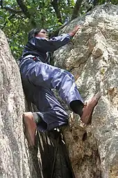 Girl wedged between two bolders, climbing