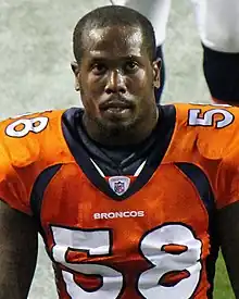 Von Miller in a Denver Broncos jersey and no helmet.