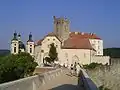 View from the west. In the middle is situated the Gothic watchtower upon the main gateway, on the left is the Holy Trinity Chapel with crypt of the Althann family beneath.