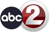 A logo with two different circular elements; a black ABC logo, then the station's main numerical logo, which features a numerical gray-gradient "2" inset into a thick circle of the same color. A contrasting dark red gradient fills in the space between the circle and the "2"