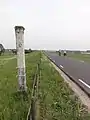 Boundary marker along the road on the Waaldijk