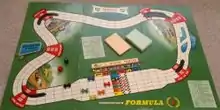 The start of a game of Waddington's Formula 1 showing board, playing pieces, card packs and dice.