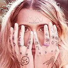 Singer Morgan Wade hiding her face in her hands, which are covered in random symbols. Near her forehead are the words "Morgan Wade" and "Reckless", as well as the letters M and W in silver.