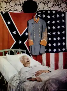 An old man resting in a bed below a Confederate flag, a gray confederate uniform, and a 48-star American flag