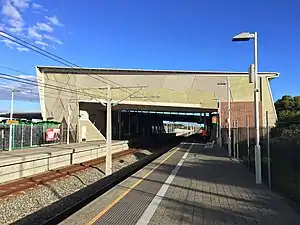 Large grey shelter over two platforms and tracks