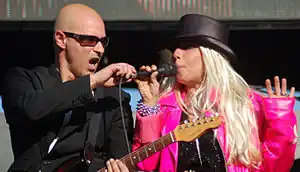 Cuccurullo holding a microphone to Dale Bozzio