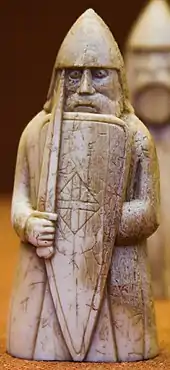 Photograph of an ivory gaming piece depicting an armed warrior