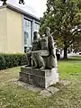 The sculpture "Seated Swimmers" in front of the swimming hall.