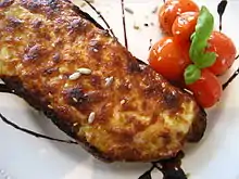 Photograph of a Welsh rarebit, melted cheese on toast