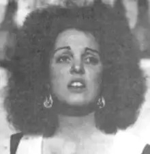 A young white woman with a teased 1970s hairdo