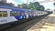 A pairing of Northern class 156 units at West Allerton on a service from Manchester Oxford Road to Liverpool Lime Street.