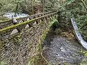 The 1939–40 WPA stone bridge across the creek, with main falls above it