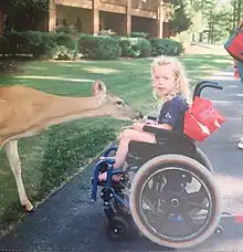 a child with cerebral palsy in a blue manual wheelchair