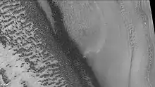 Reynolds crater showing layers and dark spots from defrosting, as seen by CTX camera (on Mars Reconnaissance Orbiter).  Area is covered by frost, when the frost disappears the underlying dark ground is exposed.  Layers are also visible.  Note: this is an enlargement of a previous image of Reynolds crater.