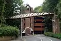 An original footbridge crosses Winchester Chesil station site. The route is blocked by multi-storey car park, behind which is the tunnel.